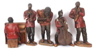 A quintet of 1920s porcelain music shop advertising statuettes, formed as an African-American jazz