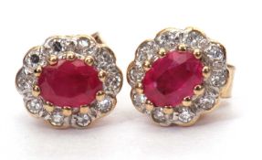 A pair of modern small ruby and diamond cluster earrings with post fittings and tested for 9ct gold