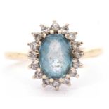 Light blue stone and diamond cluster ring, the oval shaped stone multiclaw set and raised above a