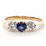 Sapphire and diamond three stone ring, the round faceted sapphire is flanked by two round