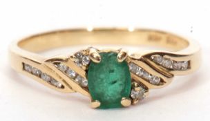 Modern emerald and diamond ring, the central round faceted emerald (chipped) set between diamond