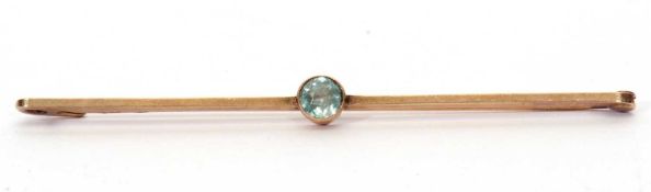 Vintage aquamarine brooch centering a round faceted aquamarine on a plain polished bar, stamped 9ct,