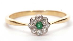 Small emerald and diamond cluster ring, a flower head design centering a round cut emerald within