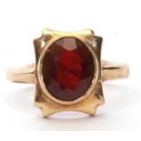 9ct gold garnet set ring, the oval faceted garnet is 10 x 8 mm bezel set in a shaped box mount,