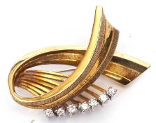 Yellow metal stylised ribbon brooch highlighted with seven small round brilliant cut diamonds, total