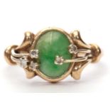 9ct gold jade and diamond ring, the oval cabochon shaped jade panel is bezel set with overlapping