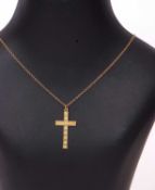 Small 9ct stamped cross pendant suspended from a trace chain with a barrel clasp, stamped 9ct