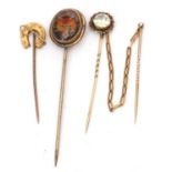 Group of three stick pins to include a 9ct stamped horseshoe example, a painted glass fox head