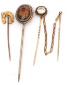 Group of three stick pins to include a 9ct stamped horseshoe example, a painted glass fox head