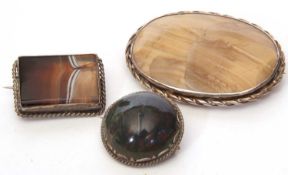 Three agate brooches, a large oval example, a rectangular banded agate brooch together with a