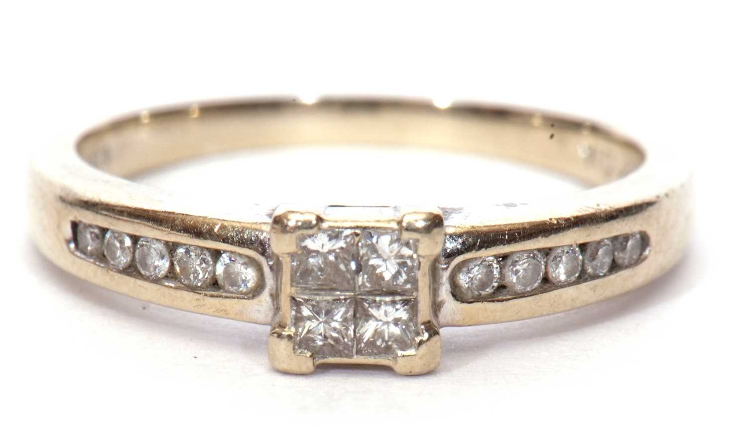 A modern diamond set ring, the square panel set with four small princess cut diamonds and raised