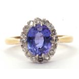 Tanzanite and diamond cluster ring, the oval faceted tanzanite 14 x 8mm raised within a small single