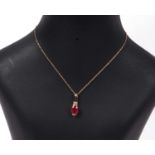 Ruby and diamond pendant, the oval faceted ruby is 1.35ct approx, highlighted above with two small