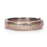 Hallmarked silver hinged bracelet, the top section chased and engraved with scrolls and foliate