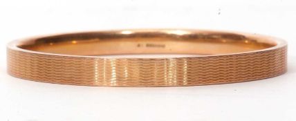 9ct gold bangle with overall engraved with a wavey line design, hallmarked for Birmingham 1926,