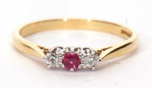 18ct gold ruby and diamond three stone ring centering a small round cut ruby flanked by two round