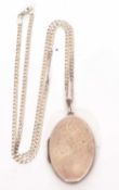 White metal oval locket, part chased and engraved with scrolls suspended from a 925 stamped chain