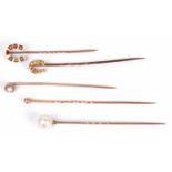 Five stick pins to include 9ct gold horseshoe example set with small seed pearls, a garnet and ruby,