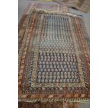 Antique Middle Eastern wool floor rug decorated with a central panel with stylised motif