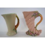 Two Clarice Cliff jugs , one of cornucopia form with floral handle and anither similiar. Largest