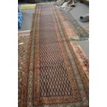 Antique causasian runner carpet decorated with a large central panel of stylised floral motifs on