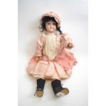 Early 20th Century doll, the bisque head marked EM6 in pink dress with glass eyes, 60cm long