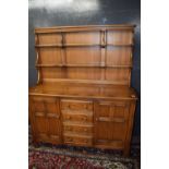Ercol elm dresser with shelved back over a base with two panelled doors and four drawers, 146cm