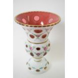 Two Bohemian style glass vases, the cranberry ground with white glass overlay painted with