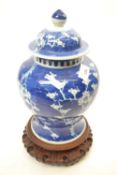 Large Chinese porcelain ginger jar and cover on carved wooden stand, the blue ground decorated