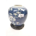 Chinese porcelain ginger jar, the blue ground decorated with prunus, the jar with carved wooden