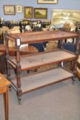 Victorian mahogany three tier buffet cabinet with turned and carved uprights and brass casters,