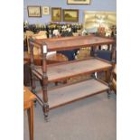 Victorian mahogany three tier buffet cabinet with turned and carved uprights and brass casters,