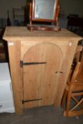 A pine cupboard with arched door