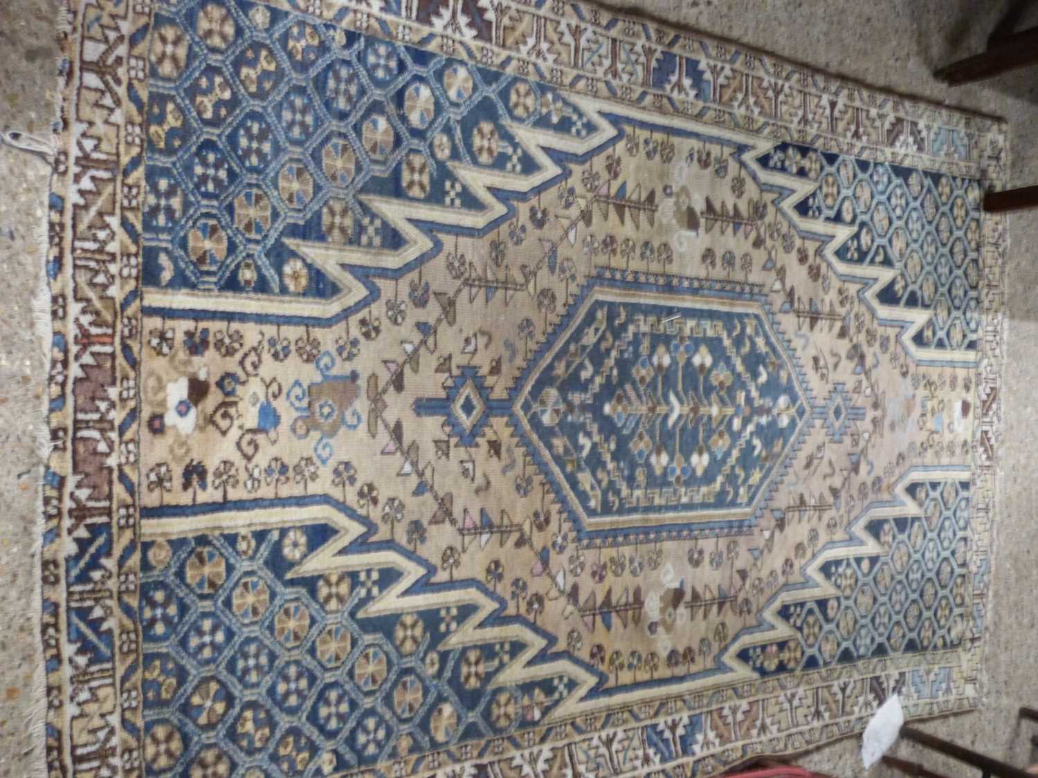 Middle Eastern wool floor rug decorated with large central panel on a blue and beige background,