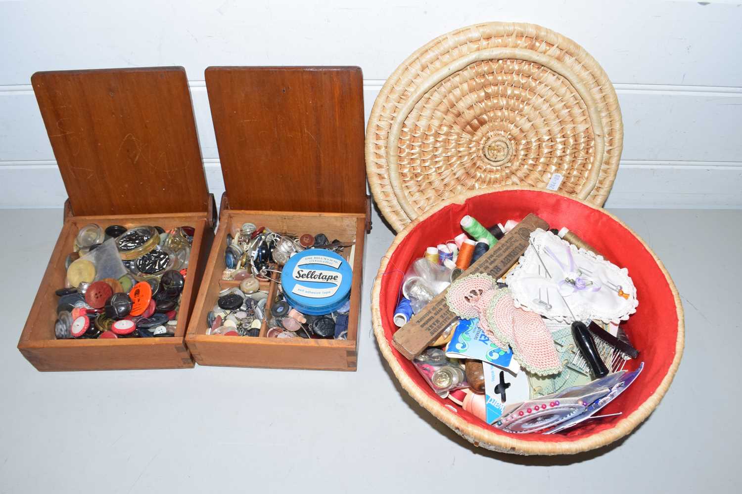 Two wooden boxes and a wicker basket of various buttons and sewing supplies