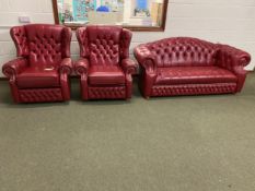 Red leather button back and studd Chesterfield style sofa and pair of reclining chairs (with fire