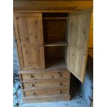 Modern pine wardrobe with 3 drawers below 2 cupboard doors, to hanging rail and central shelf, 92