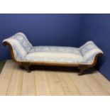 A decorative chaise longue upholstered in a blue and white floral fabric, on raised turned legs to