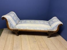 A decorative chaise longue upholstered in a blue and white floral fabric, on raised turned legs to