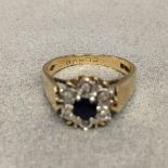 9 ct gold sapphire and diamond ring central circular cut sapphire with a surround of single cut