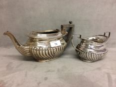 A two piece sterling silver tea set,the teapot and sugar with half reeded design, Chester, 1899,