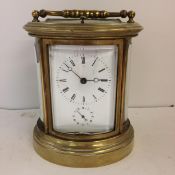 French oval gilt brass four pane carriage clock, striking on a bell with key