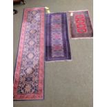 3 rugs: a runner with red border and blue and floral central panel, and 2 smaller red and blue