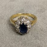 18ct gold sapphire and diamond dress ring central oval free cut sapphire, 8mm & 6mm, with a surround