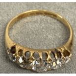 An 18ct gold and diamond five stone ring, set with graduated line of old cut diamonds in a scrolling