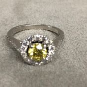 Platinum fancy yellow diamond and diamond halo ring, central 0.64ct brilliant cut fancy yellow