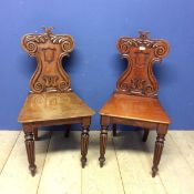 Pair of mahogany shield shaped back hall chairs, with some wear and fading