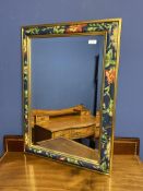 A decorative mirror with hand painted floral and gold coloured border