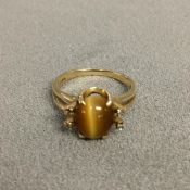 14ct gold dress ring set with central cabochon cut oval tigers eye, with single cut diamond accents,