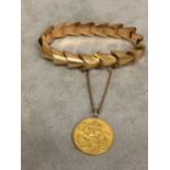 Unmarked yellow metal bracelet with 1911 George V gold sovereign, 29.7g